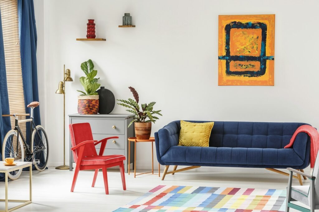 Red chair and royal blue lounge placed in bright sitting room in